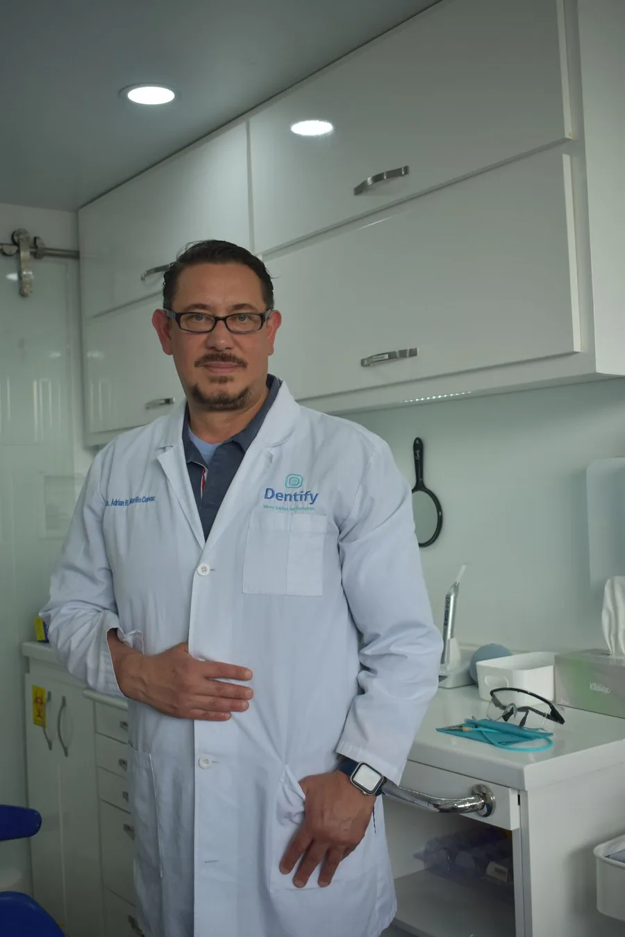 Photograph of a dentist in a white coat in a modern dental office